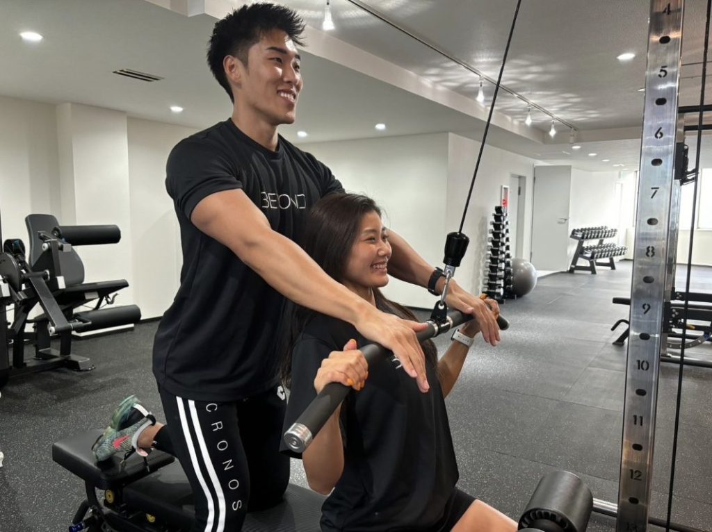 背中トレーニングを指導する男性トレーナーとお客様